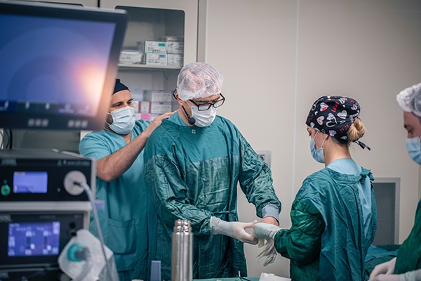 A nurse anesthetist and other healthcare professionals getting ready for a surgery