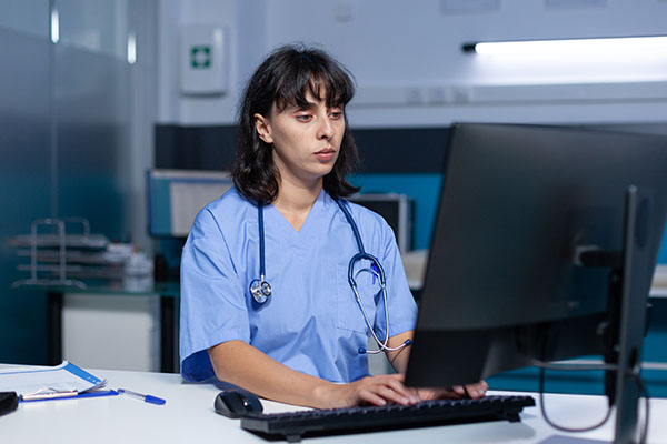 A nurse looking at a computer