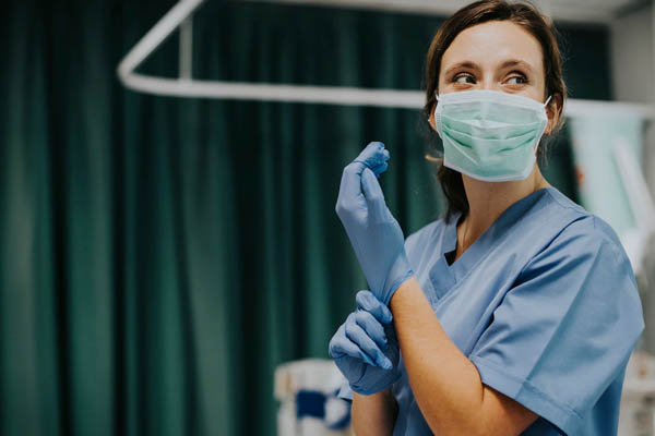 A nurse putting on medical gloves