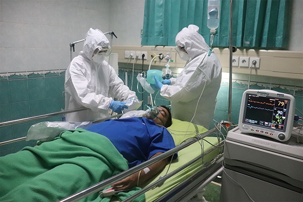 healthcare workers with a patient laying on a hospital bed