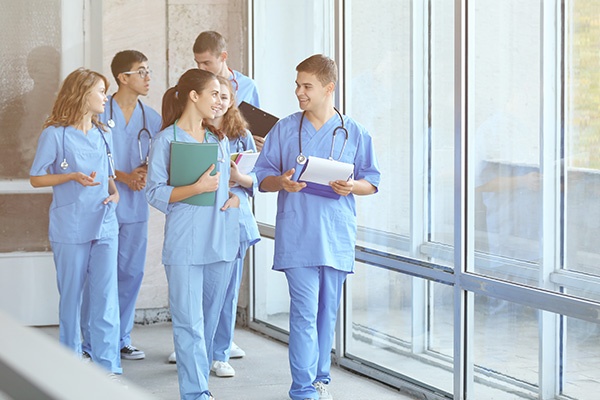 A group of nursing students walking together in a hallway of a hospital