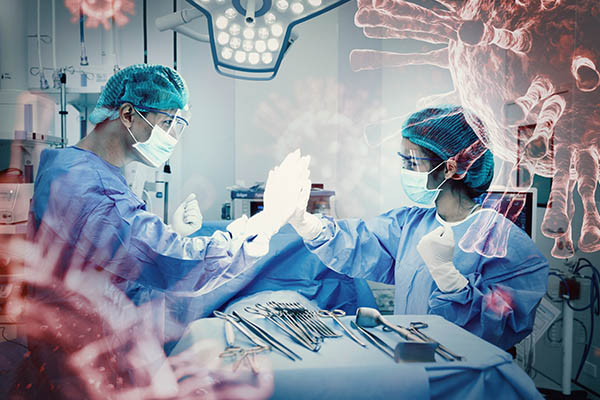 Two healthcare professional high-fiving in an operating room
