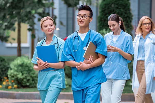 Nursing students walking together outside with folders in their hands
