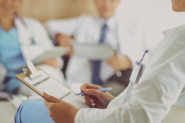 A healthcare person with a clipboard in their hand