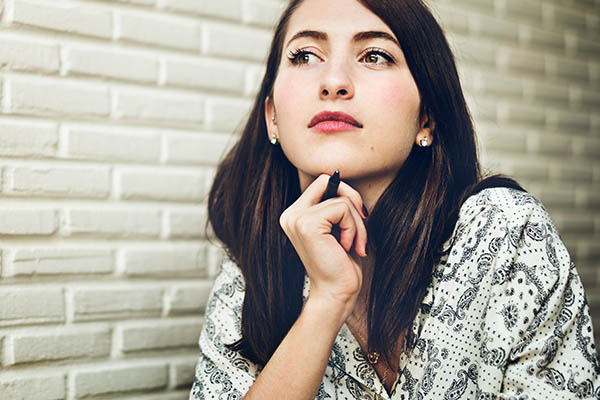 A woman with her hand under her chin like she is thinking