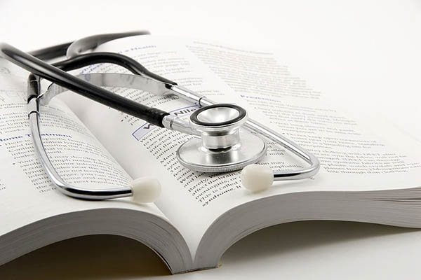 A stethoscope resting on top of an open book