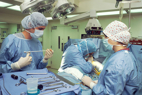 A nurse anesthetist and other healthcare workers in the operating room with a patient
