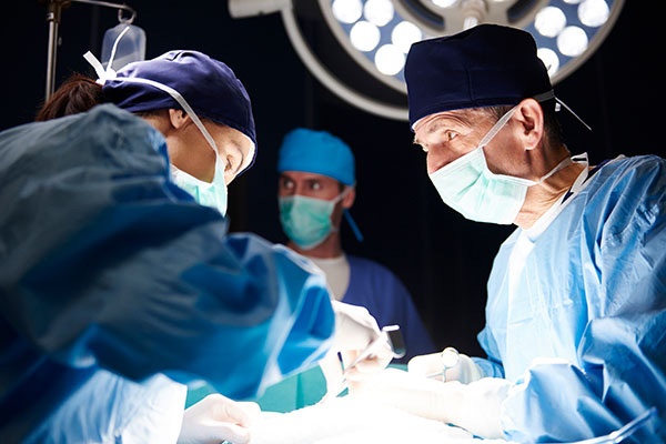 A CRNA and team of doctors with a patient during an operation 