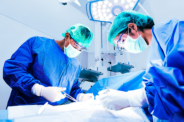 Two surgeons leaning over a patient during an operation