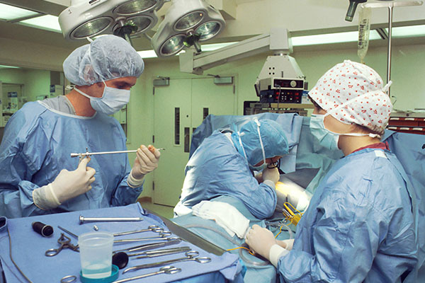 A nurse anesthetist and team of healthcare workers in an operating room performing surgery