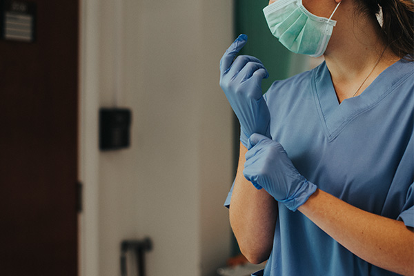 A nurse putting on gloves