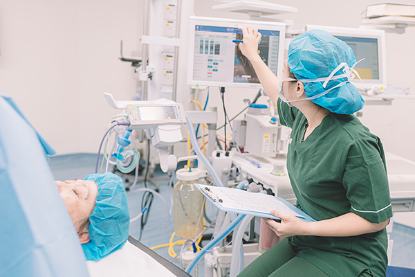 Nurse anesthetist monitoring patient during surgery
