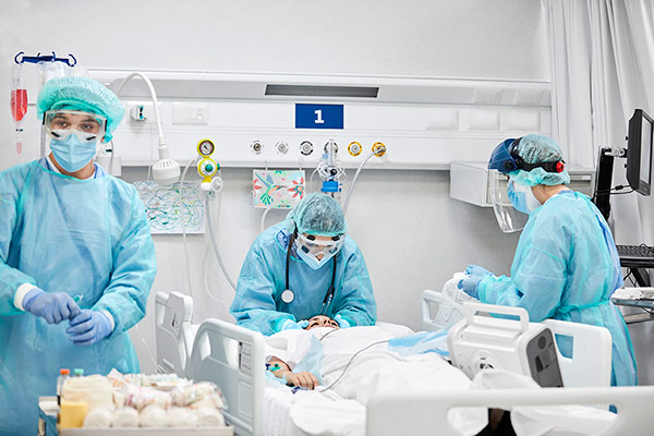 A team of nurses around a patient in a hospital room