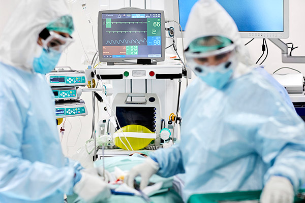 two medical professionals in an operating room with anesthesia equipment nearby