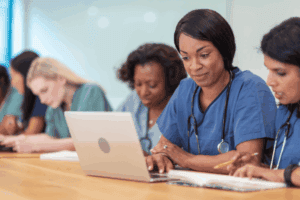 Nurses in CRNA school looking up information on a laptop