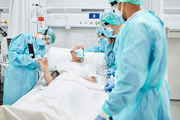 A team of nurses and a nurse anesthetist with a patient who is laying in a hospital bed