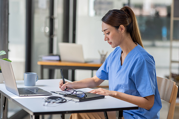 A nurse anesthesia resident studying at a laptop
