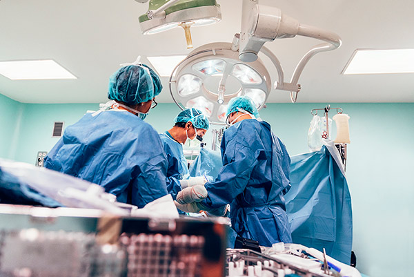 A nurse anesthetist and surgeons in an operating room