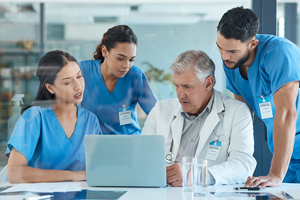 Nurses and a doctor looking at a laptop together