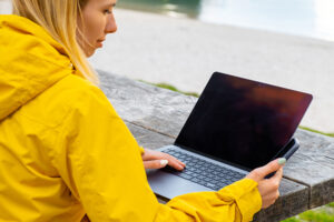 A woman sitting at a picnic table with a laptop