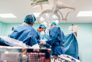 A nurse anesthetist and team of surgeons operating on a patient in an operating room