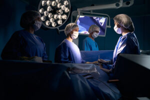 A CRNA and other medical professionals in an operating room during surgery