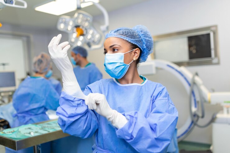 A nurse anesthetist putting on gloves in an operating room
