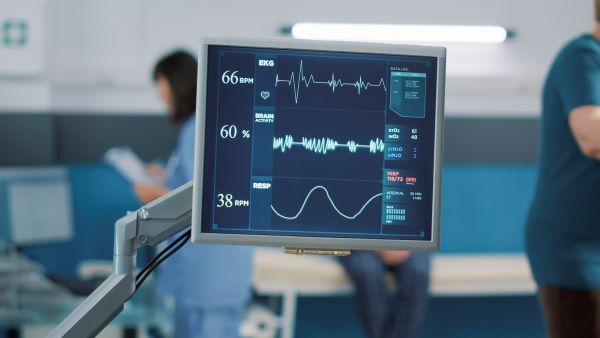 A monitor in a hospital room showing heart rate and other vital signs
