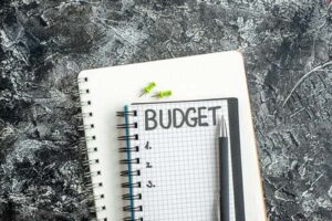 A photo of a notebook and pen with the word "Budget" written across the top of the page