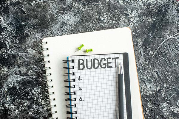 A graphic depicting a pen and paper with the word budget written across the top