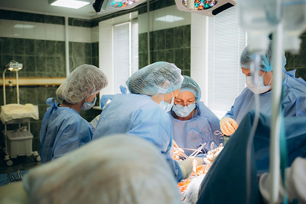 a team of surgeons and nurse anesthesia providers operate on a patient in an OR