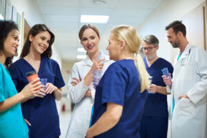 a group of healthare workers in a hallway clapping for one of the employees