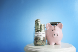 A piggy bank with a jar full of money next to it