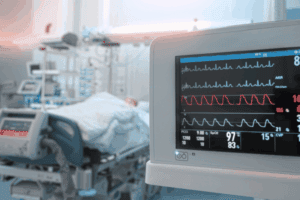 An ICU patient with hemodynamics monitor in the foreground
